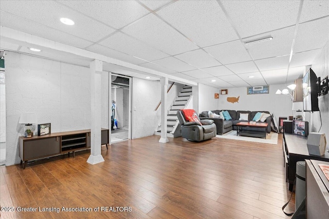 living room with a drop ceiling and hardwood / wood-style flooring