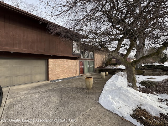 snow covered property featuring a garage