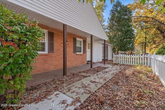 view of side of property with brick siding and fence