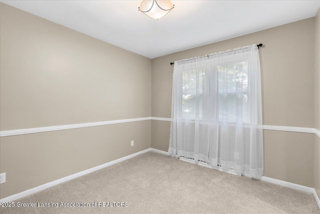 carpeted empty room with baseboards