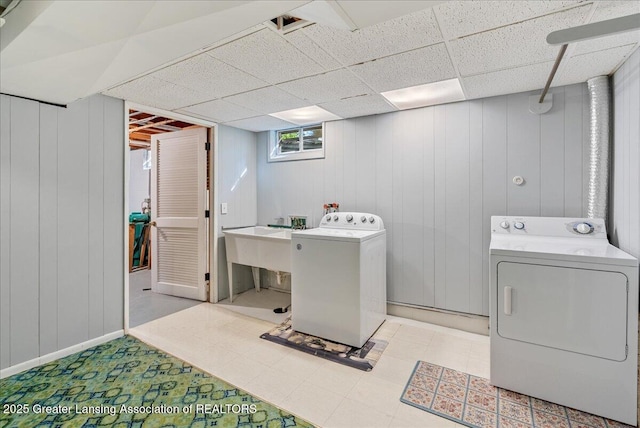 laundry area featuring a sink, laundry area, light floors, and washing machine and clothes dryer