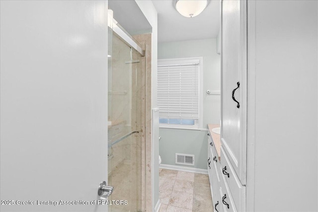 full bathroom featuring visible vents, baseboards, toilet, a stall shower, and vanity