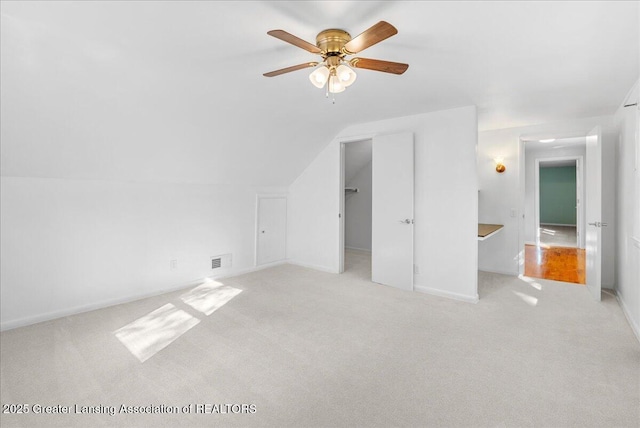 bonus room with visible vents, light carpet, lofted ceiling, baseboards, and ceiling fan