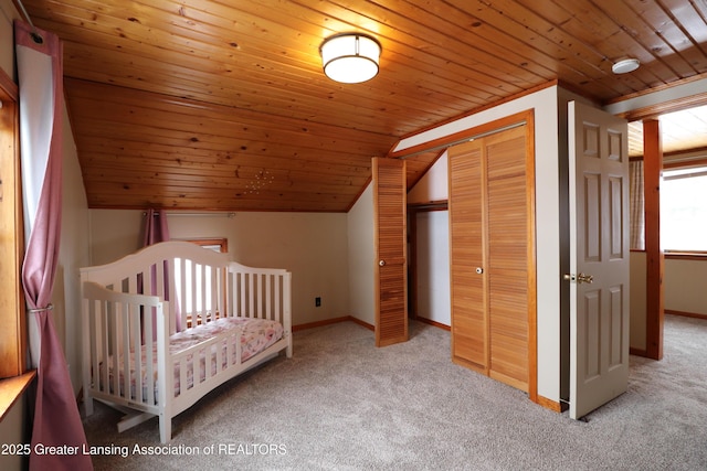 unfurnished bedroom featuring wood ceiling, a closet, lofted ceiling, and carpet