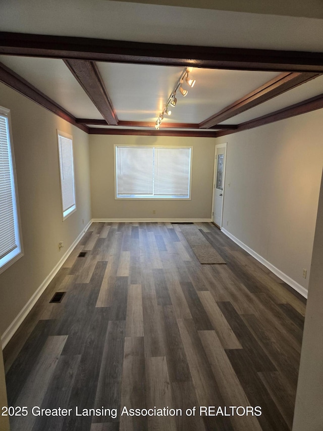 empty room featuring beam ceiling and dark hardwood / wood-style floors