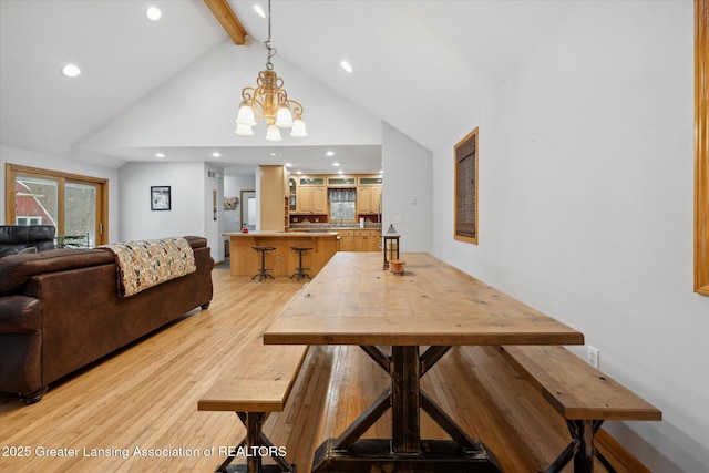 dining room featuring a notable chandelier, beam ceiling, light hardwood / wood-style floors, and high vaulted ceiling