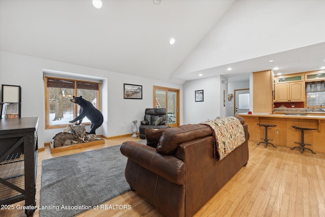 living room featuring high vaulted ceiling and light wood-type flooring