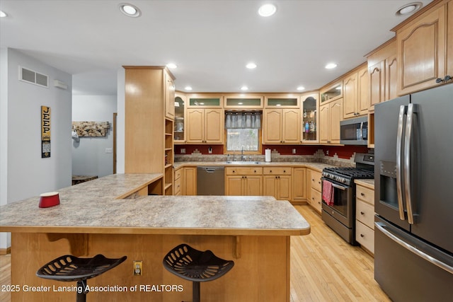 kitchen featuring light brown cabinetry, sink, stainless steel appliances, and light hardwood / wood-style floors