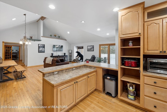 kitchen featuring pendant lighting, vaulted ceiling with beams, light hardwood / wood-style floors, kitchen peninsula, and light brown cabinets