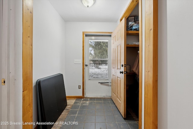 doorway to outside with dark tile patterned flooring