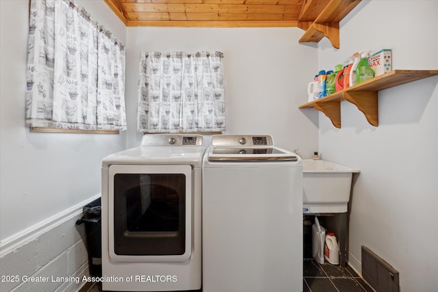 clothes washing area with wood ceiling and washer and clothes dryer