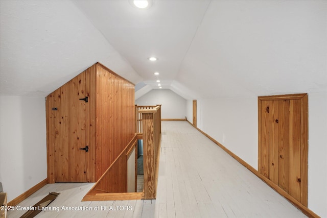 additional living space with hardwood / wood-style flooring and lofted ceiling