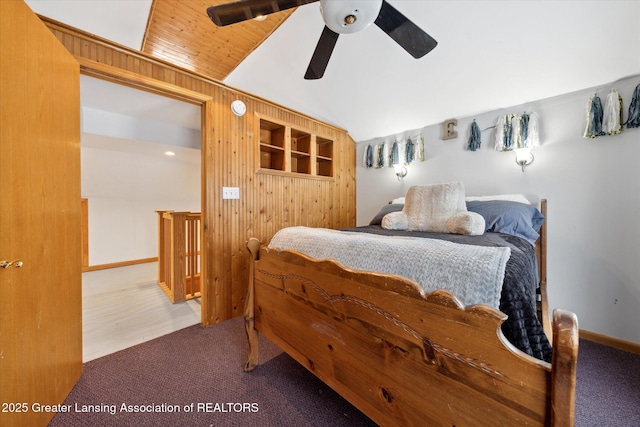 bedroom featuring ceiling fan, lofted ceiling, carpet, and wooden walls