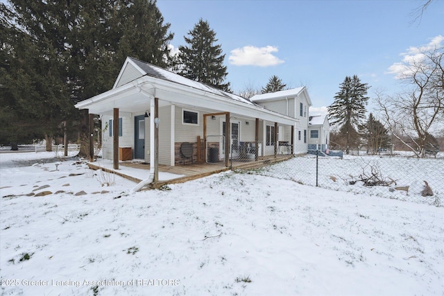 snow covered property with covered porch