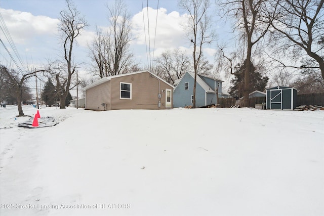 snowy yard with a storage shed