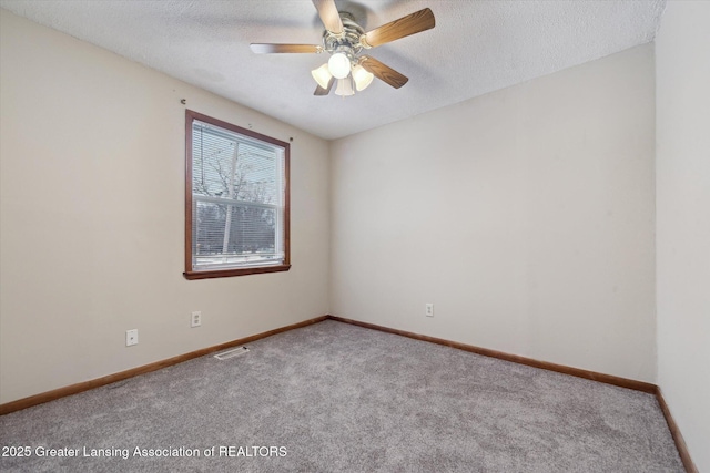 carpeted empty room with ceiling fan and a textured ceiling