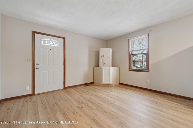 entrance foyer featuring a healthy amount of sunlight, light hardwood / wood-style flooring, and a textured ceiling