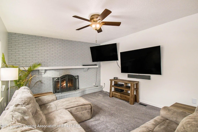 carpeted living room with a brick fireplace, a textured ceiling, and ceiling fan