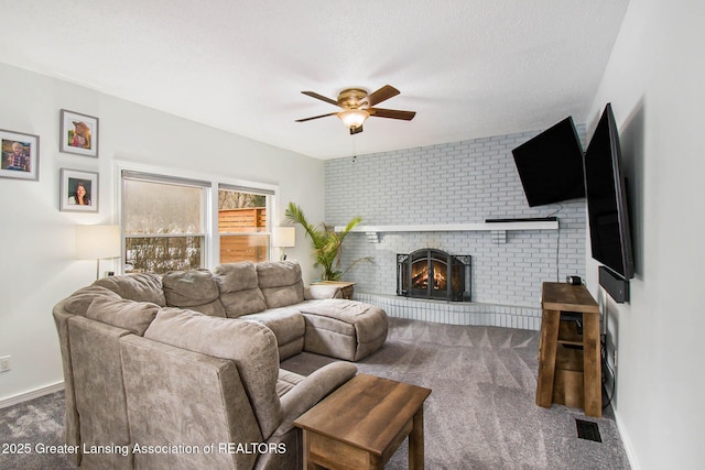 carpeted living room with a brick fireplace, a textured ceiling, and ceiling fan