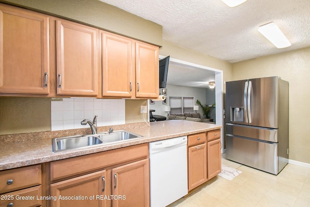 kitchen featuring sink, dishwasher, stainless steel refrigerator with ice dispenser, tasteful backsplash, and a textured ceiling