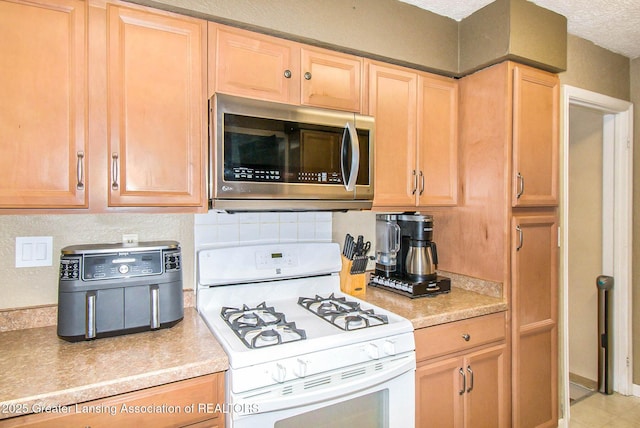 kitchen featuring tasteful backsplash, a textured ceiling, and white gas range oven