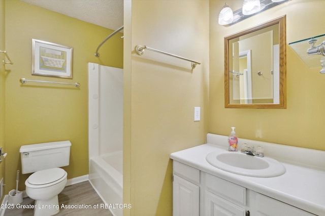 full bathroom with shower / bathing tub combination, wood-type flooring, vanity, toilet, and a textured ceiling