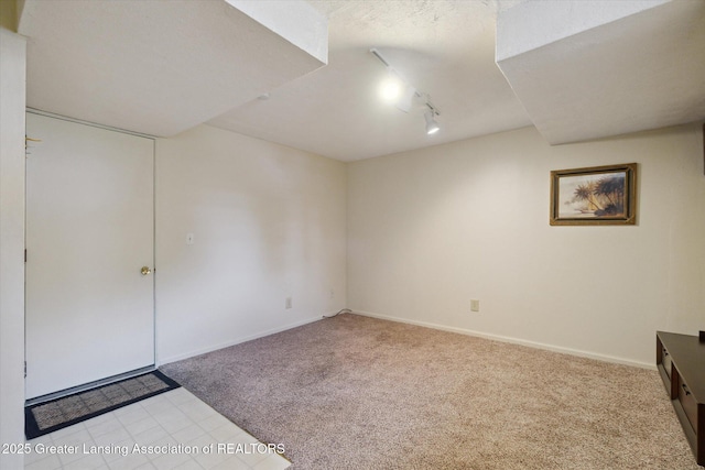 unfurnished room with light carpet, track lighting, and a textured ceiling