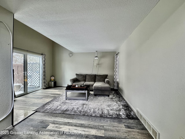 living room with hardwood / wood-style flooring and a textured ceiling