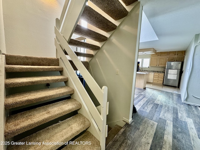 stairs with sink and wood-type flooring