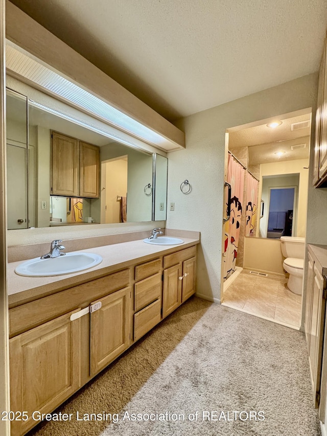 bathroom with vanity, tile patterned floors, toilet, and a textured ceiling