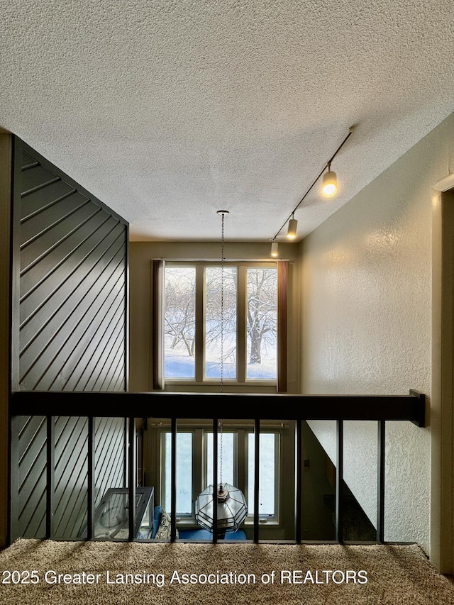 interior space featuring track lighting and a textured ceiling