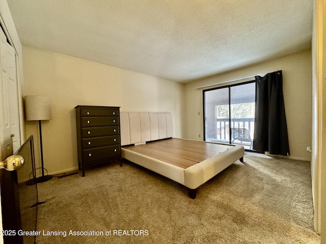 bedroom featuring access to outside, light colored carpet, and a textured ceiling