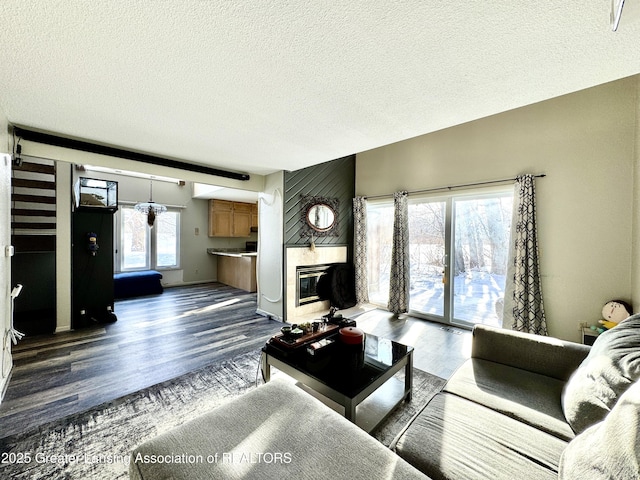 living room with a fireplace, dark hardwood / wood-style floors, and a textured ceiling