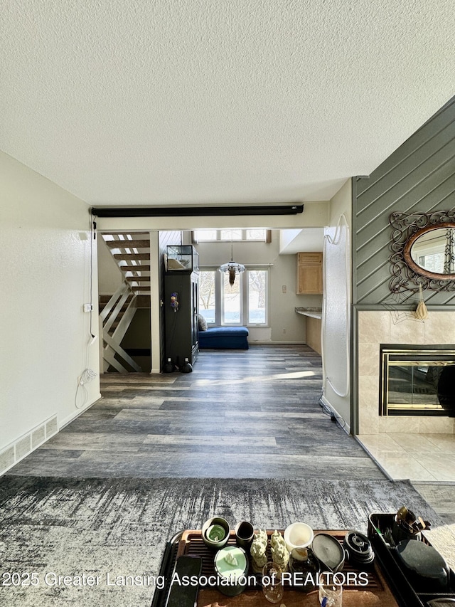 interior space featuring hardwood / wood-style flooring, a fireplace, a textured ceiling, and wood walls