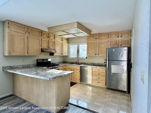 kitchen with sink, kitchen peninsula, stainless steel appliances, light brown cabinets, and a textured ceiling