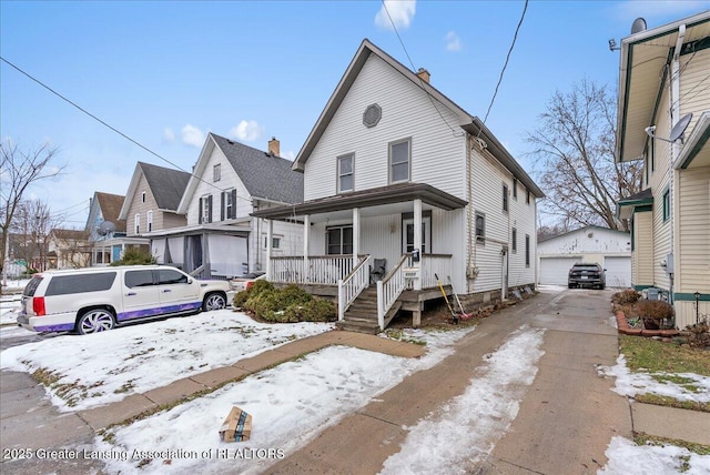 view of front of home featuring a garage, an outdoor structure, and a porch