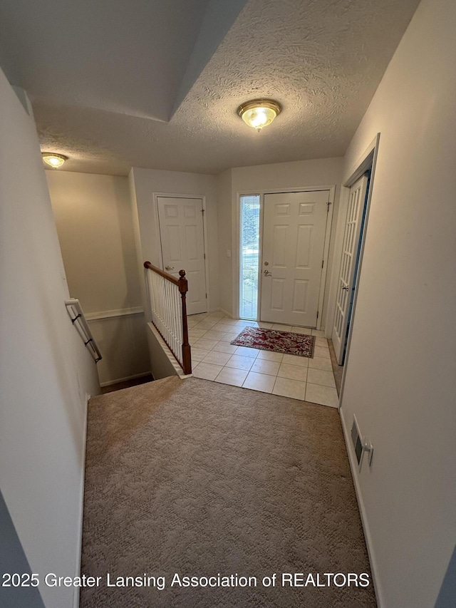 tiled entrance foyer featuring a textured ceiling