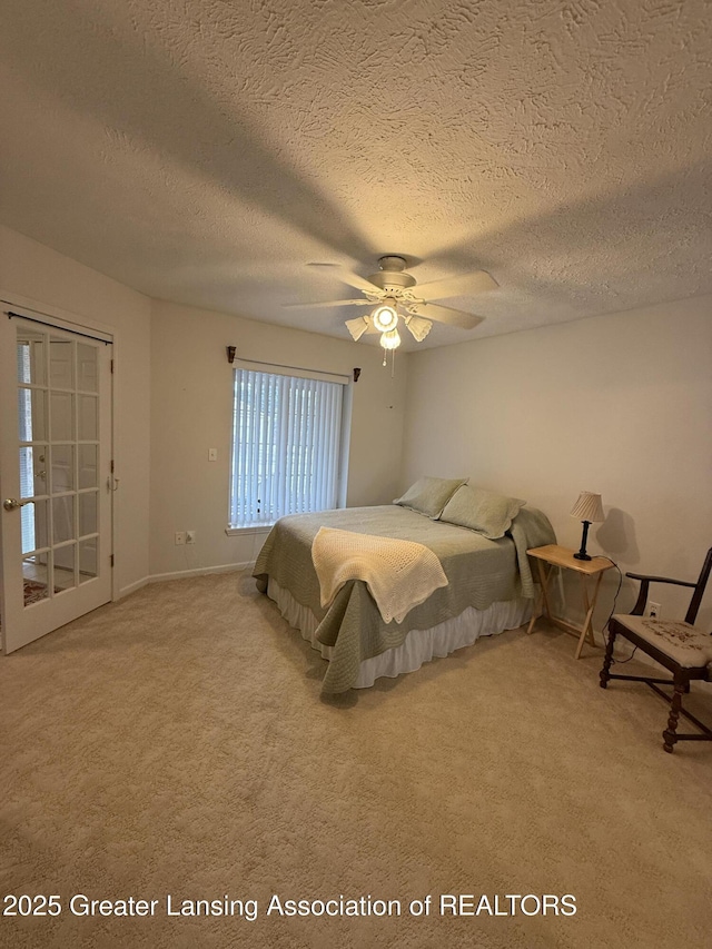 bedroom featuring ceiling fan, light colored carpet, and a textured ceiling