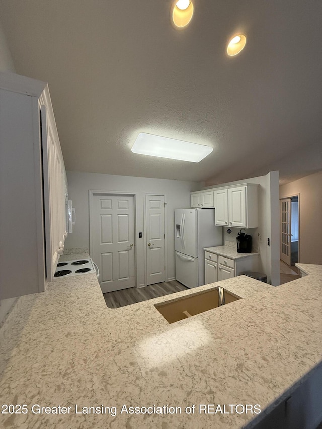 kitchen featuring white cabinetry, sink, white appliances, and hardwood / wood-style floors