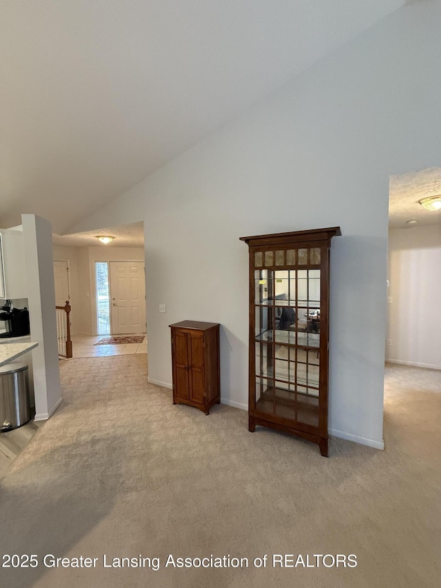 living room with light carpet and high vaulted ceiling