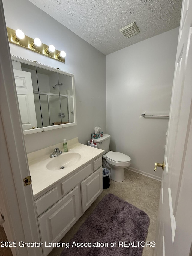 bathroom with vanity, an enclosed shower, a textured ceiling, and toilet