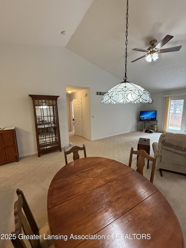 carpeted dining space featuring vaulted ceiling and ceiling fan