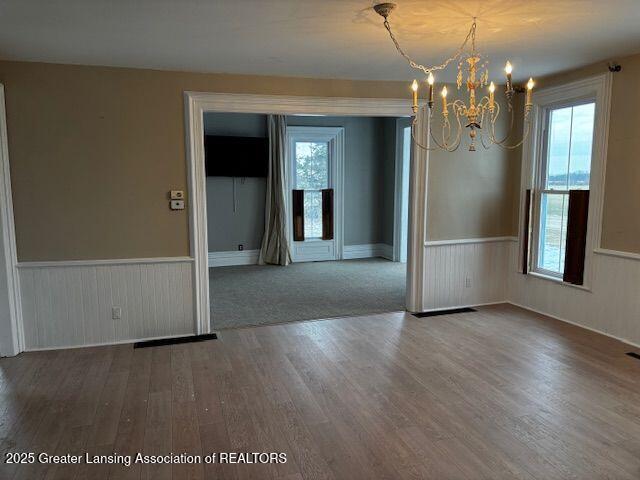 unfurnished room featuring hardwood / wood-style flooring and a chandelier