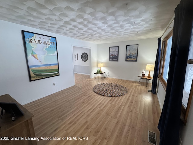 hallway featuring a textured ceiling and light hardwood / wood-style flooring