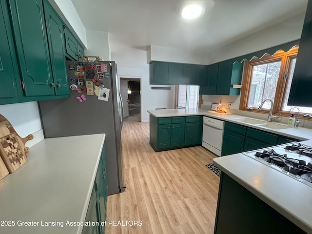 kitchen featuring sink, stainless steel refrigerator, white dishwasher, kitchen peninsula, and light hardwood / wood-style floors