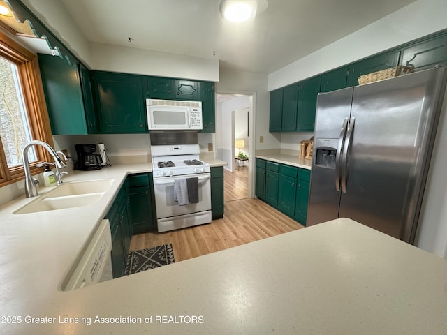 kitchen with white appliances, sink, and light wood-type flooring