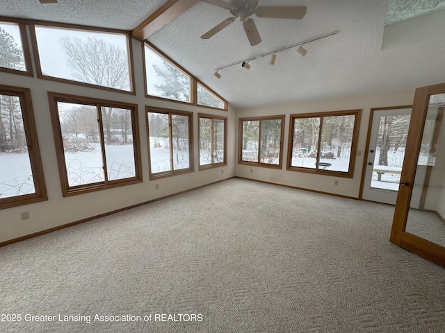 unfurnished sunroom featuring lofted ceiling with beams, rail lighting, and ceiling fan