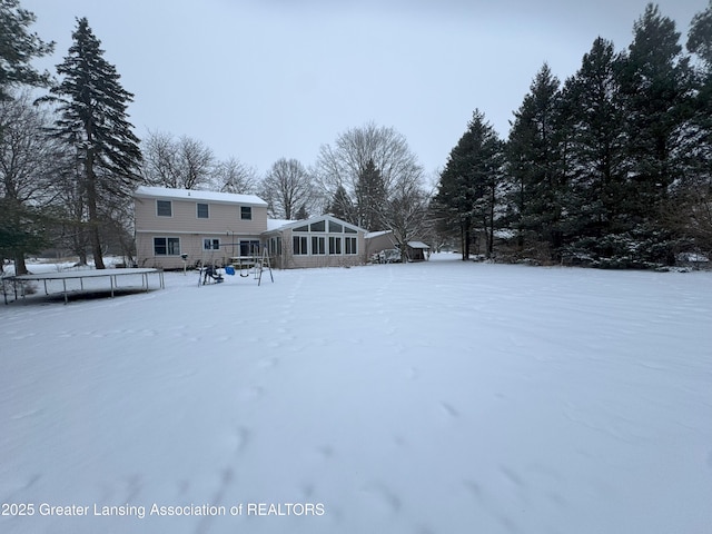 snowy yard featuring a trampoline