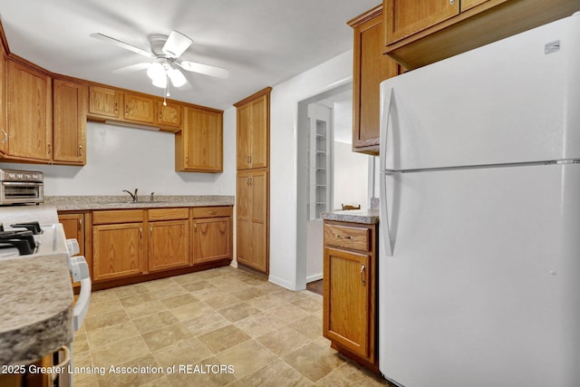 kitchen with white refrigerator, sink, and ceiling fan