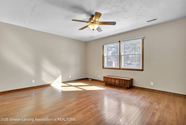 unfurnished room featuring ceiling fan, light hardwood / wood-style floors, and a textured ceiling